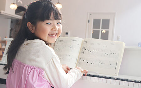 笑顔でピアノを弾く少女