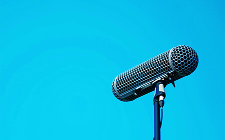 大空を背景に立っているマイク